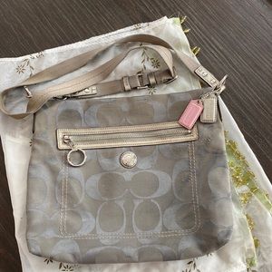 Grey canvas Coach crossbody bag with purple interior.